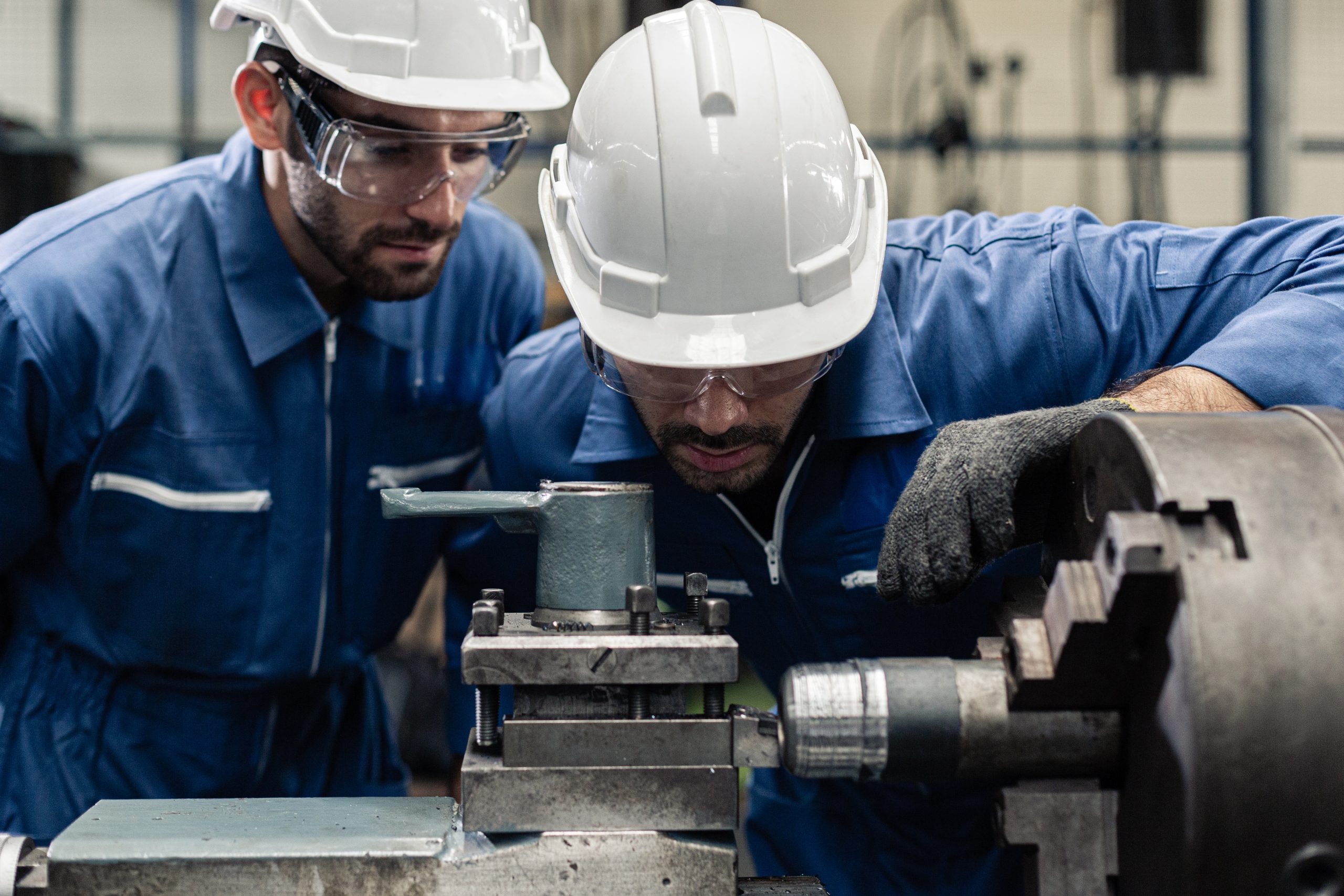 Engineer men wearing uniform safety in factory working machine lathe metal.